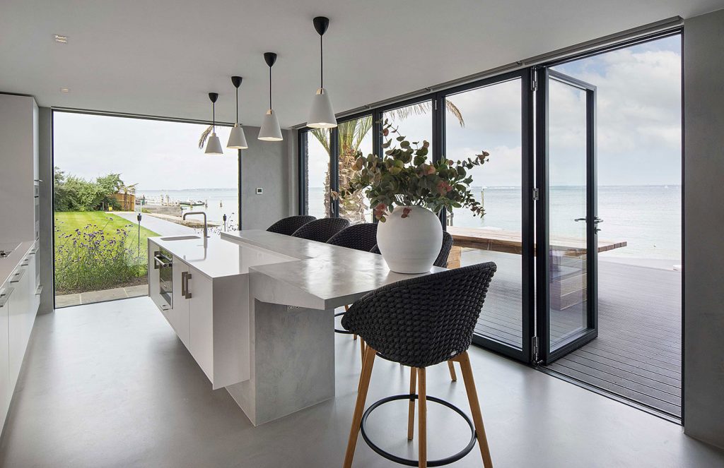 Minimalist kitchen design with architectural features and stunning view of the sea