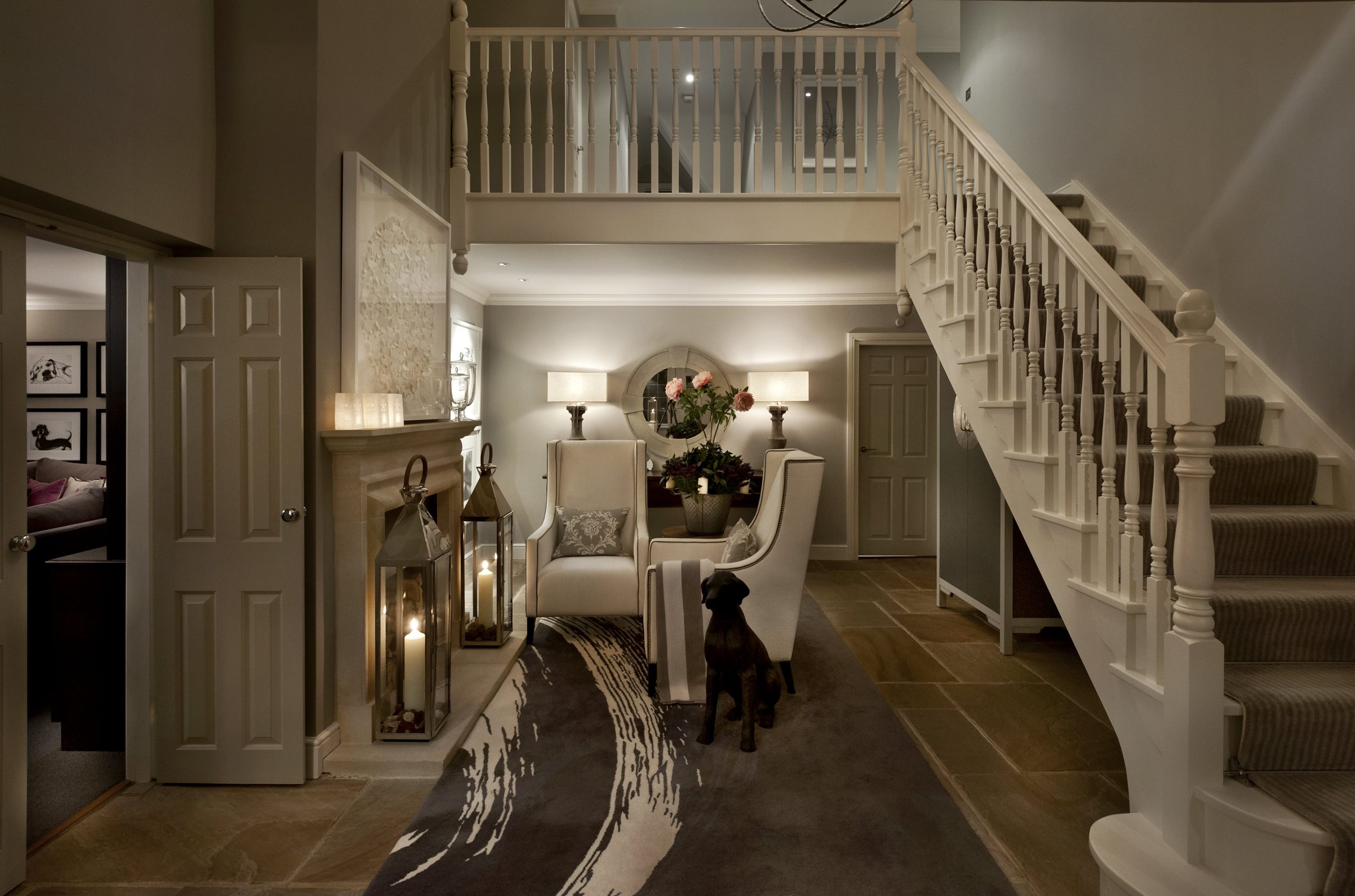 Stunning and welcoming entrance interior design with open staircase and fireplace with soft lighting