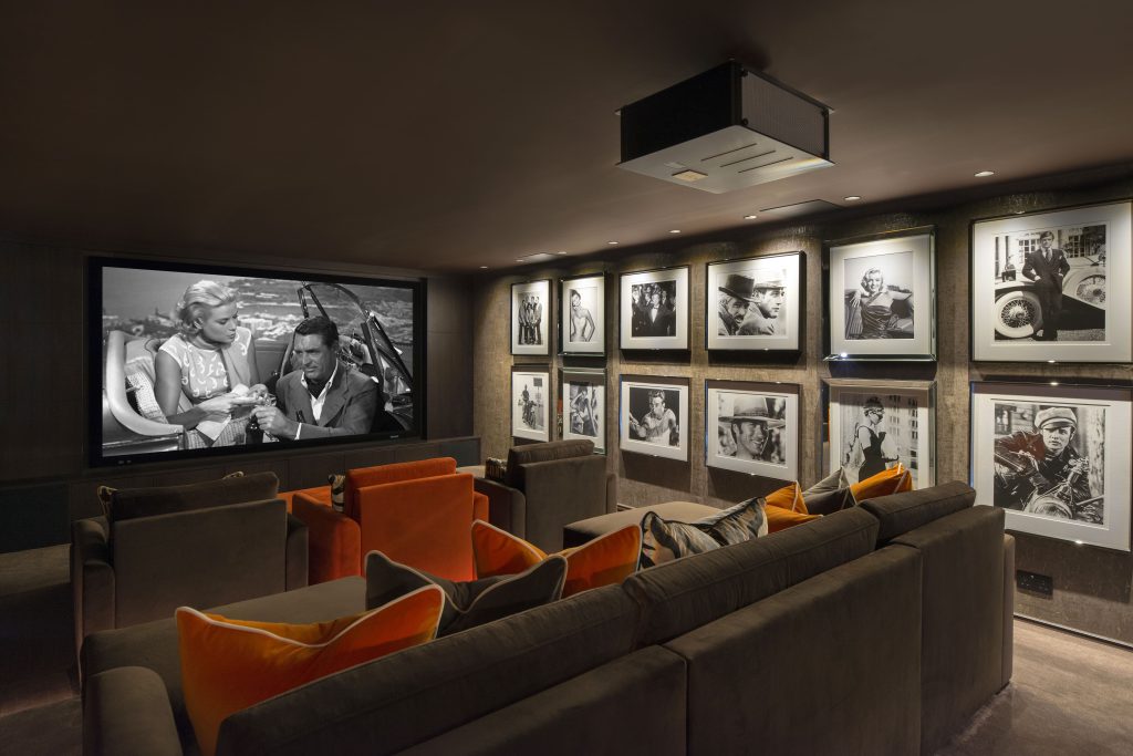 Large high end home cinema design with collection of holly wood greats artwork big tv projector screen