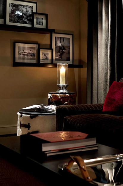 Animal hide side tables with collection of artwork on display shelving