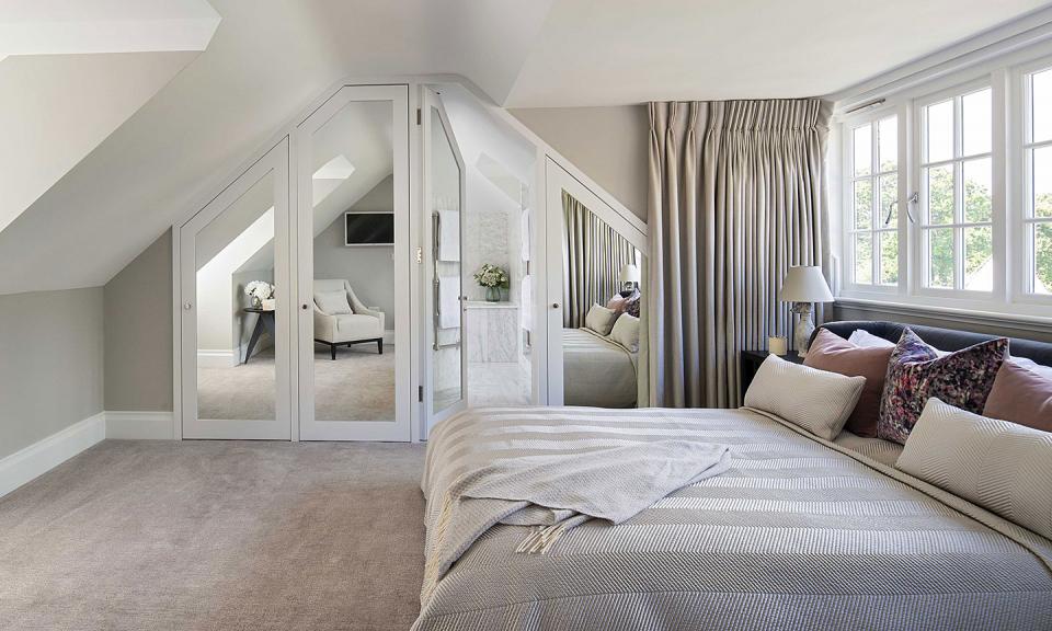 Hidden ensuite bathroom behind bespoke mirrored joinery curved curtains round bay window