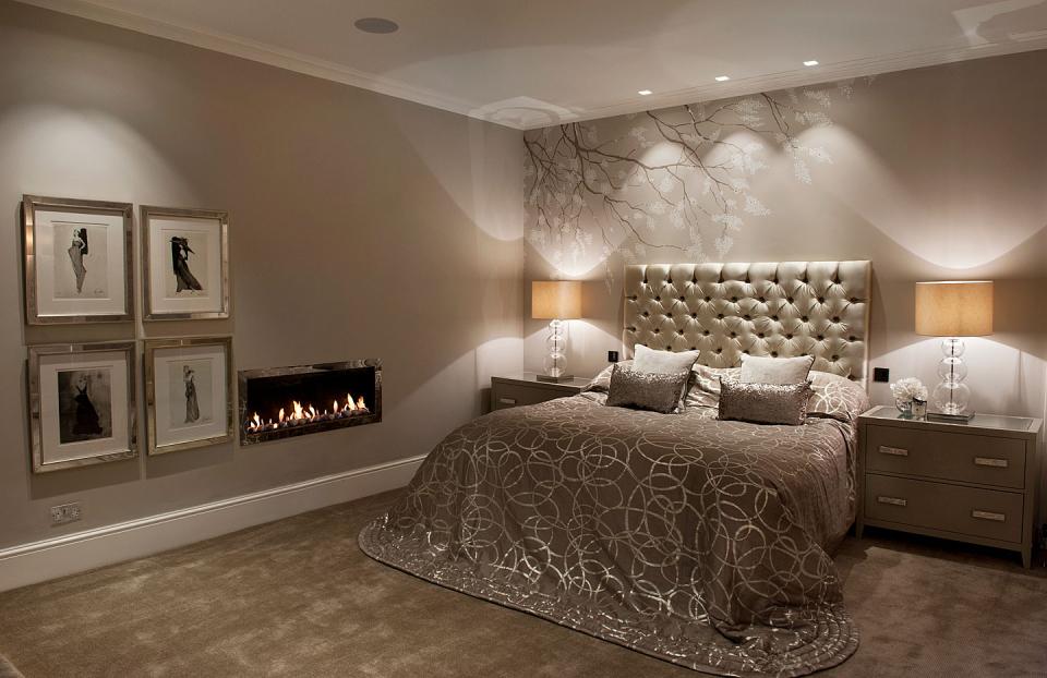 A cosy romantic bedroom interior with a fire and hand painted wall paper