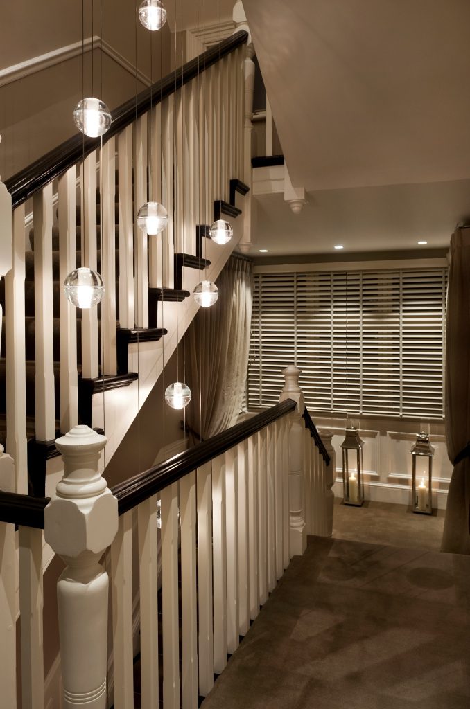 Gorgeous landing and staircase design with cascading globe pendant between floors