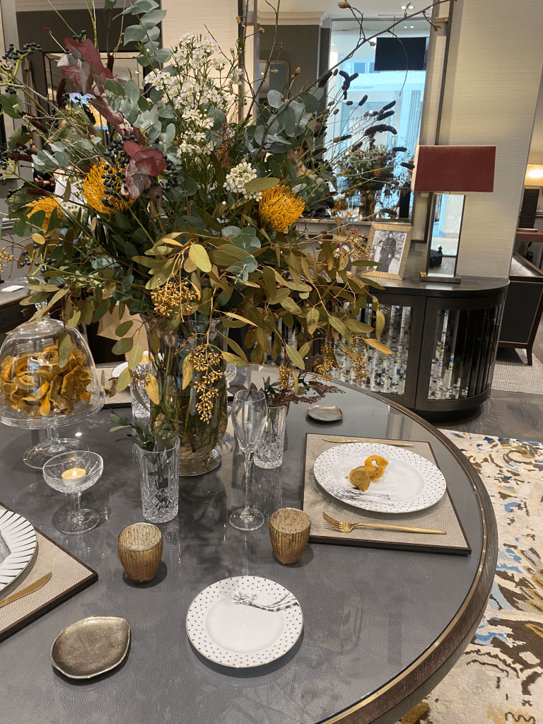 dining table set up with a large foliage display centre piece
