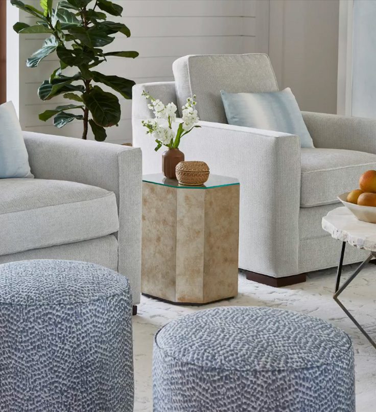 cream and blue interior designed living room with armchairs side table and foot stools