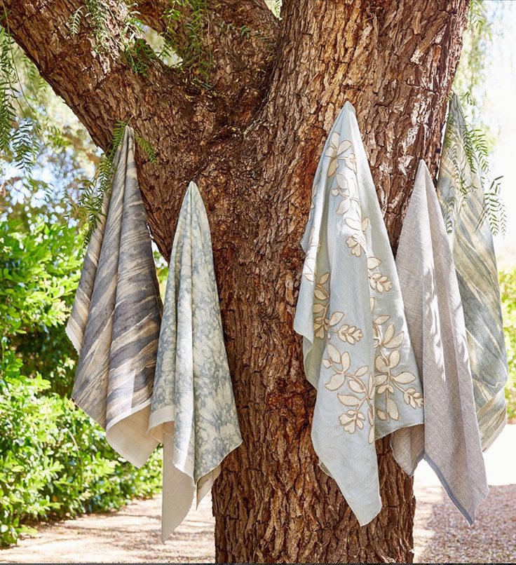 blue hanging luxury fabrics from a tree to promote a new collection
