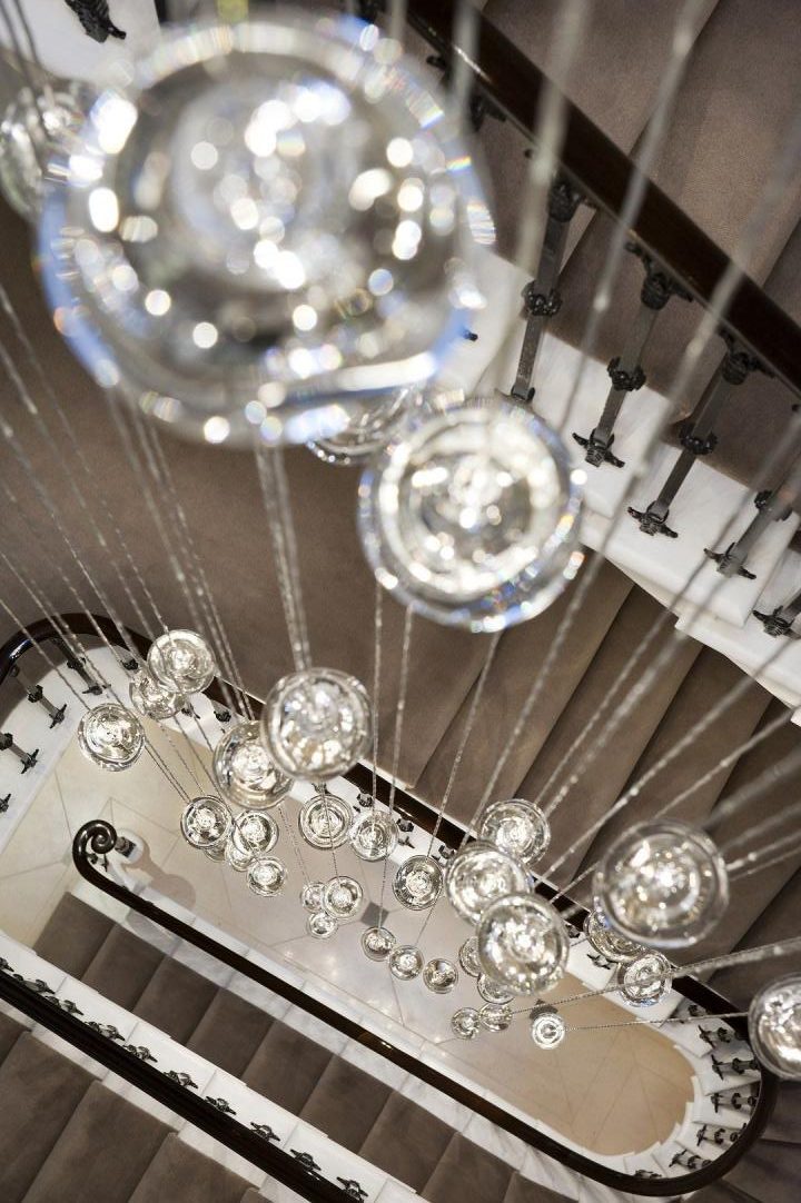 Gorgeous landing and staircase design with cascading globe pendant between floors